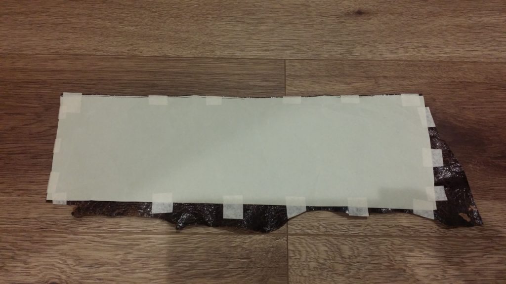 型紙をテープで革の表面に貼ります。